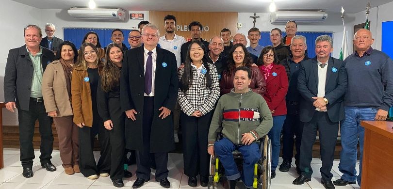 Justiça Eleitoral participa de posse de vereadores mirins na Câmara Municipal de Nova Aurora Fotografia em que aparecem várias pessoas posando em uma salão. Entre essas pessoas estão o pres...
