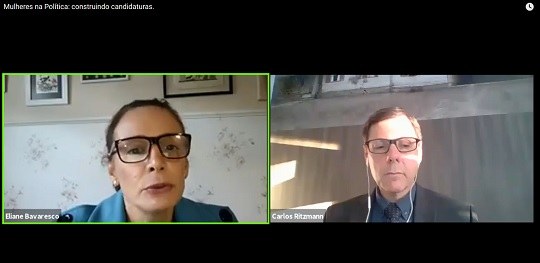 Reprodução de uma tela de reunião virtual. Há uma mulher do lado direito e, à esquerda, um homem