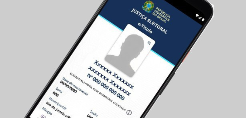 Imagem na qual é possível ver a tela de um celular, com o aplicativo do e-Título aberto, nele é ...