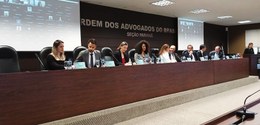 Fotografia de várias autoridades na Ordem dos Advogados do Brasil - Seção Paraná. Elas estão sen...