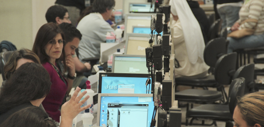 Foto de pessoas sendo atendidas por colaboradores da Justiça Eleitoral do Paraná na Central de A...
