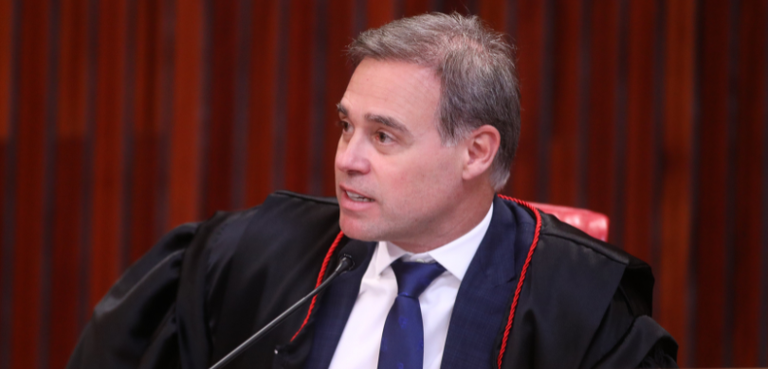 Ministros Nunes Marques e André Mendonça são eleitos presidente e vice do TSE 3 Fotografia em plano médio de um homem de pele clara, com cabelos curtos e castanhos, levemente g...