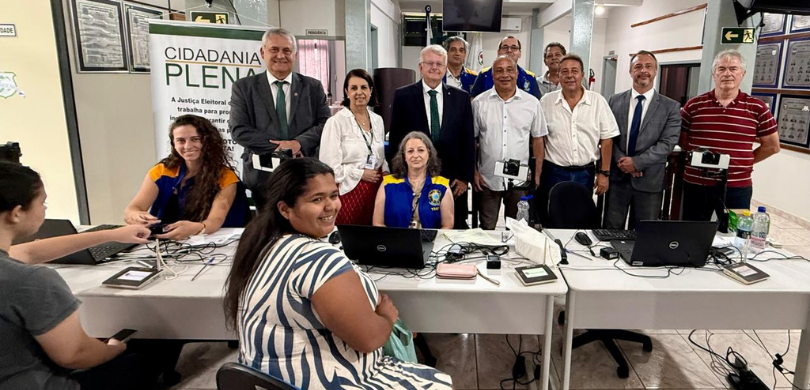 Fotografia de diversas pessoas, entre homens e mulheres, posando sorrindo. Duas mulheres, que ve...