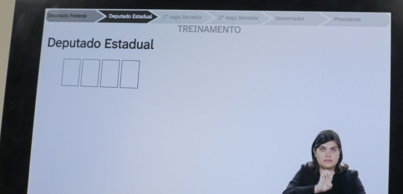 Na imagem, vê-se a tela do terminal de votação da urna eletrônica. Na parte superior, há uma bar...