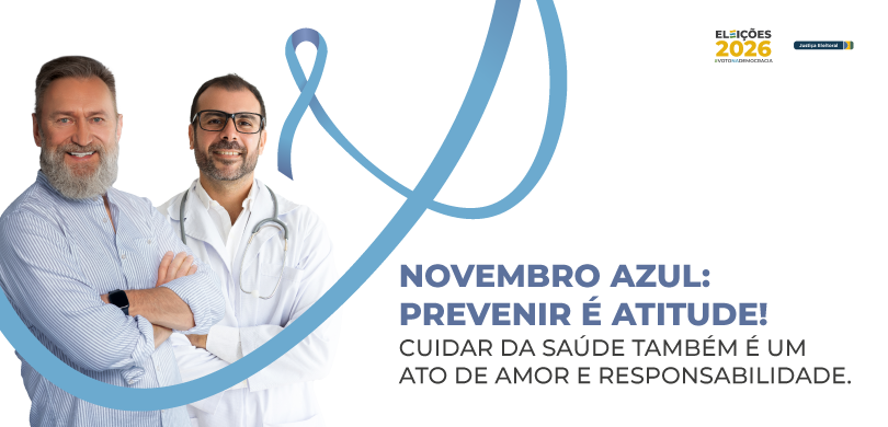 Banner em fundo branco, com a fotografia de dois homens de braços cruzados. Um deles veste uma c...