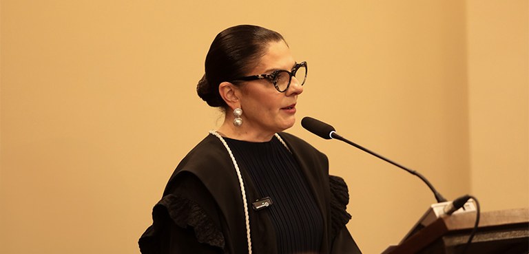 Novos membros da Corte da classe de Juiz de Direito tomam posse no TRE-PR 3 Fotografia da desembargadora eleitoral Vanessa Jamus Marchi falando em um púlpito. Ela tem cabel...