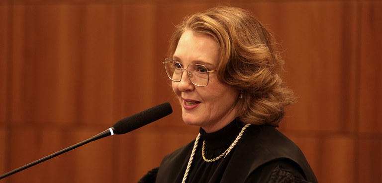 Novos membros da Corte da classe de Juiz de Direito tomam posse no TRE-PR 4 Fotografia da desembargadora eleitoral substituta Adriana de Lourdes Simette falando ao microfon...