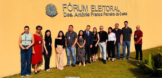 foto registrada em frente ao Fórum Eleitoral da Lapa. Servidoras e servidores estão posando para...