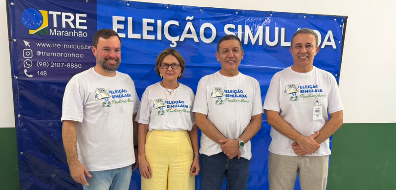 Fotografia na qual se observam quatro pessoas, sendo três homens e uma mulher, lado a lado e em ...