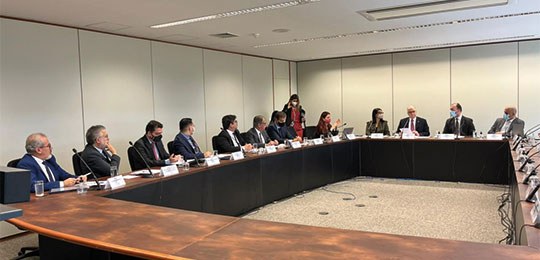 Presidente do TRE-PR apresenta as principais iniciativas da Justiça Eleitoral do Paraná ao Ministro Edson Fachin Fotografia de uma sala, com uma mesa redonda ao centro e várias pessoas sentadas ao redor dela.