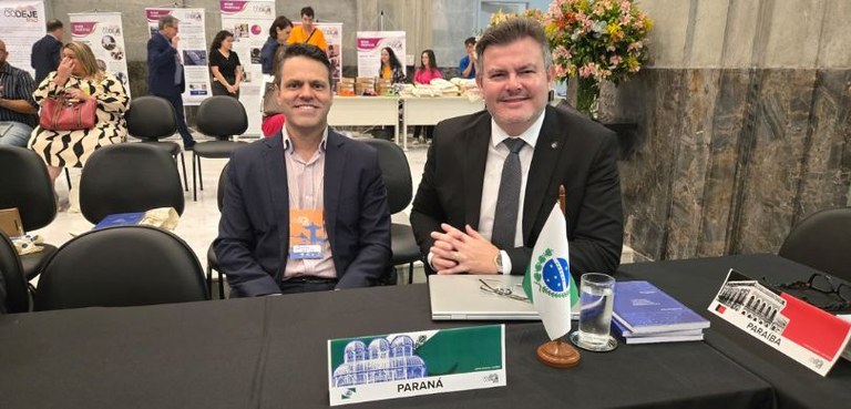 Presidente do TRE-PR e diretor-executivo da EJE-PR recebem homenagem no XXII Codeje Foto em que aparecem o desembargador Fogaça e o servidor Domício, sentados diante de uma mesa c...