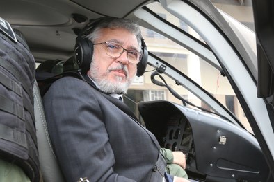 Fotografia do presidente do TRE-PR dentro do helicóptero. Ele aparece olhando para a câmera.