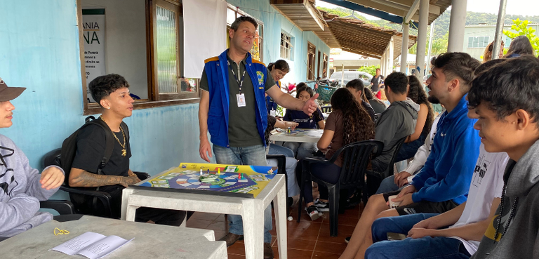 Programa “Cidadania Plena” atende 175 eleitores em Guaraqueçaba e região 4 Fotografia de um homem e de uma mulher em pé diante de mesas brancas sobre as quais há um tabule...