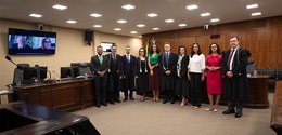 Fotografia em que são vistos os membros da Corte e advogadas e advogados posando na sala de sess...