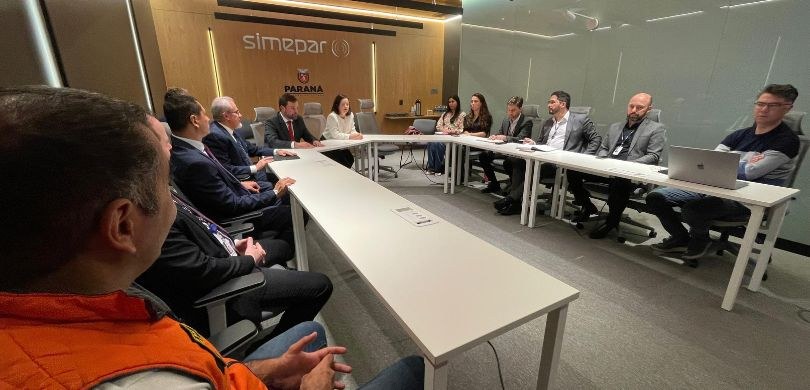 Fotografia na qual se observa um grupo de cerca de treze pessoas, entre homens e mulheres, dispo...