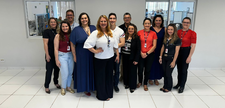 Sala calma para atendimento de pessoas com deficiência e com TEA é inaugurada em Cascavel 2 Fotografia de diversas pessoas, entre homens e mulheres, posando sorrindo em uma sala com parede...