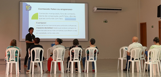 Fotografia na qual se vê uma pessoa pressionando a tecla verde de uma urna eletrônica de cor cla...