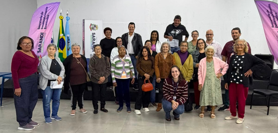 Fotografia de cinco pessoas, quatro homens e uma mulher, em uma sala clara. Dois rapazes com col...