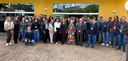 Fotografia de um grupo numeroso de aproximadamente cinquenta pessoas, entre homens e mulheres, p...