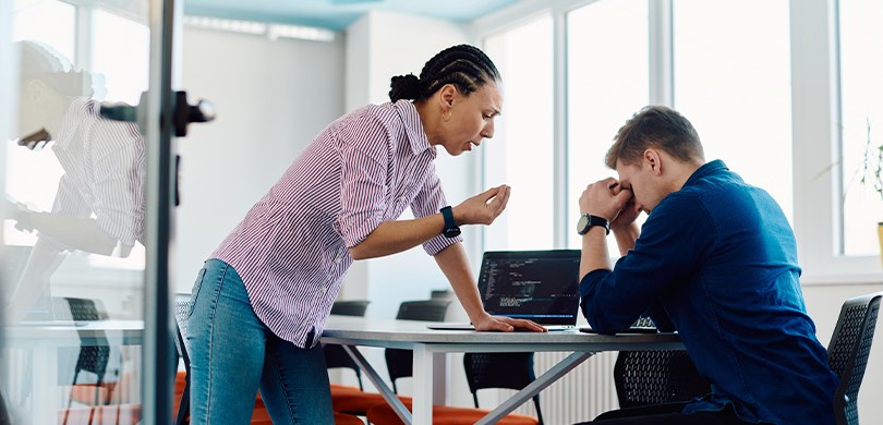 Série Assédio e Discriminação: saiba diferenciar o que é e o que não é assédio moral Fotografia de uma mulher com uma das mãos apoiadas sobre uma mesa enquanto gesticula com a outra...