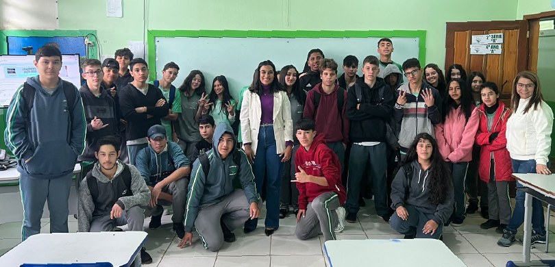 Fotografia de um grupo de vários estudantes, entre meninas e meninos, posando sorrindo em uma sa...