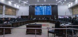 Sala do Tribunal de Justiça do Paraná (TJPR), com painel eletrônico de votação ao meio, e bancad...