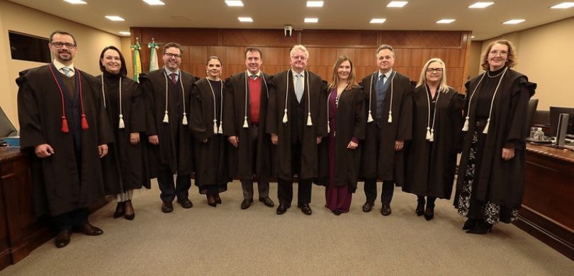 Fotografia em que aparecem os membros titulares e substitutos da Corte do TRE-PR, posando na sal...