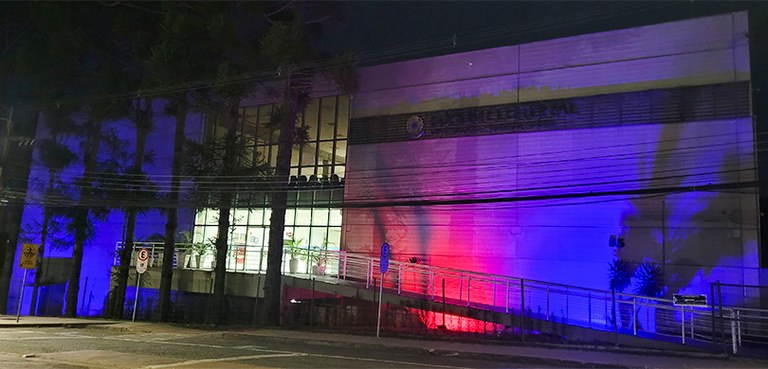 TRE-PR adere à Campanha Agosto Azul Vermelho e fachadas dos prédios são iluminadas 2 A fotografia é da fachada do Fórum Eleitoral à noite. O prédio está iluminado nas cores vermelho...