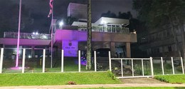 Fotografia da fachada do edifício-sede do TRE-PR à noite. A fachada está sendo iluminada na cor ...