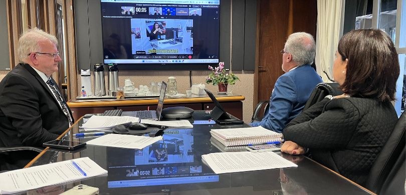 TRE-PR apresenta programa Cidadania Plena na 25ª edição do Disseminando Boas Práticas Fotografia em que aparece de lado o presidente Sigurd e de costas a diretora Solange e o secretá...