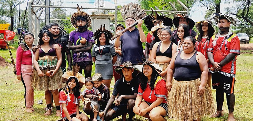 Fotografia de diversas pessoas indígenas, entre homens e mulheres, posando sorrindo ao redor de ...
