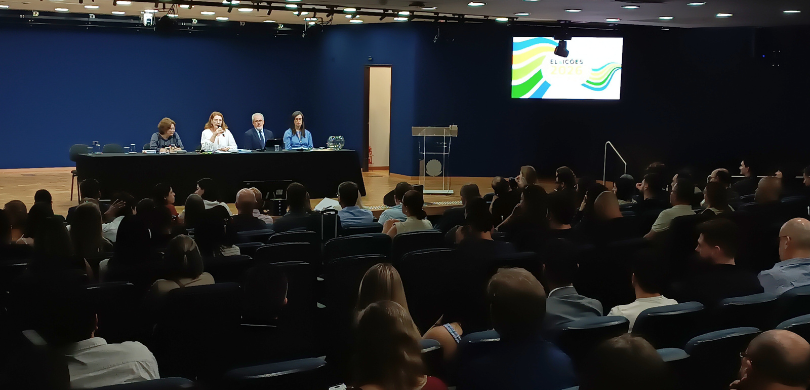 Fotografia de um auditório lotado durante um evento institucional. Em primeiro plano e no plano ...