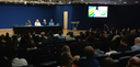 Fotografia de um auditório lotado durante um evento institucional. Em primeiro plano e no plano ...