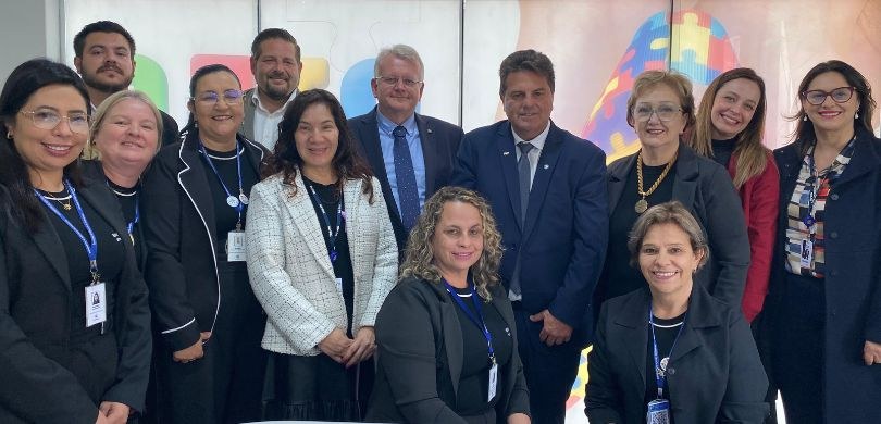 TRE-PR e Prefeitura de Guarapuava assinam protocolo para promover inclusão de crianças e adolescentes com TEA Fotografia em que aparecem várias pessoas posando sorrindo em uma sala. Entre elas, está o presi...