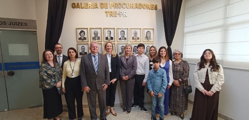 Fotografia em que aparecem várias pessoas posando em frente à Galeria de Procuradores do TRE-PR,...
