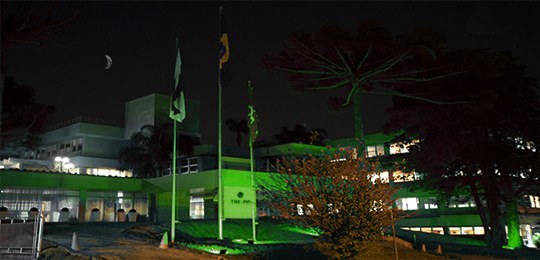 Foto da fachada do Tribunal Regional Eleitoral do Paraná (TRE-PR) sendo iluminada de verde