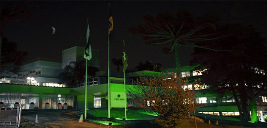 Foto da fachada do Tribunal Regional Eleitoral do Paraná (TRE-PR) sendo iluminada de verde