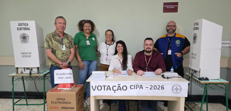TRE-PR participa da eleição da CIPA do Hospital de Clínicas Fotografia de três mulheres e três homens posando sorrindo. Quatro pessoas aparecem em pé e outr...