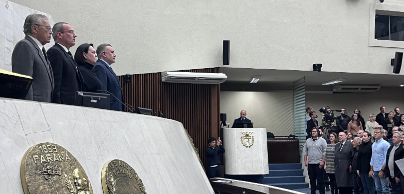 TRE-PR participa de eventos em homenagem ao Dia do Comerciante Fotografia da mesa de honra da Alep, em que se observam três homens e uma mulher. Do lado direit...