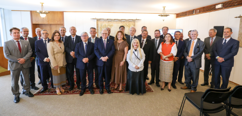 Fotografia que retrata um grupo de aproximadamente vinte e cinco pessoas, entre homens e mulhere...
