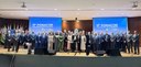 Fotografia de um grupo numeroso de pessoas, composto por homens e mulheres, posando em pé sobre ...