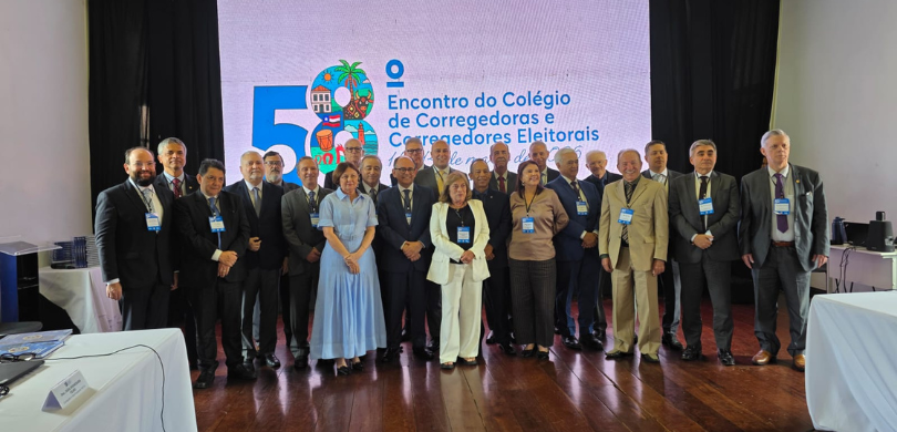 Fotografia em que se observa um grupo de aproximadamente vinte e cinco pessoas, entre homens e m...