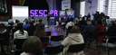 Fotografia em perspectiva ampla que mostra a realização de um evento em um auditório com público...