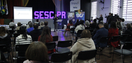 Fotografia em perspectiva ampla que mostra a realização de um evento em um auditório com público...