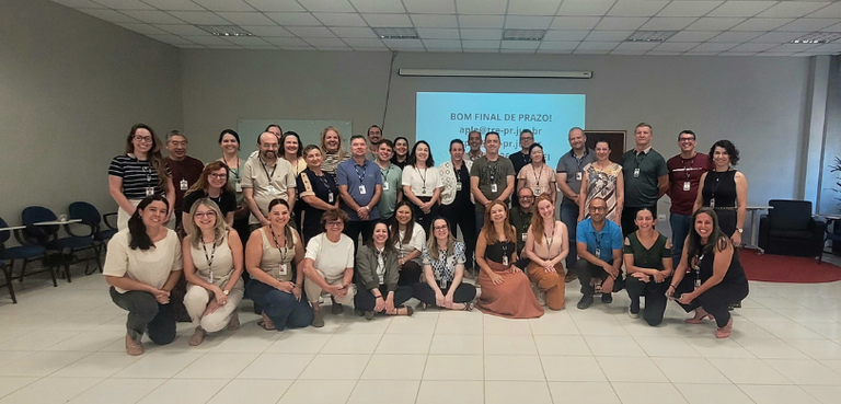Fotografia de um grupo de aproximadamente 35 pessoas, entre homens e mulheres, posando para uma ...