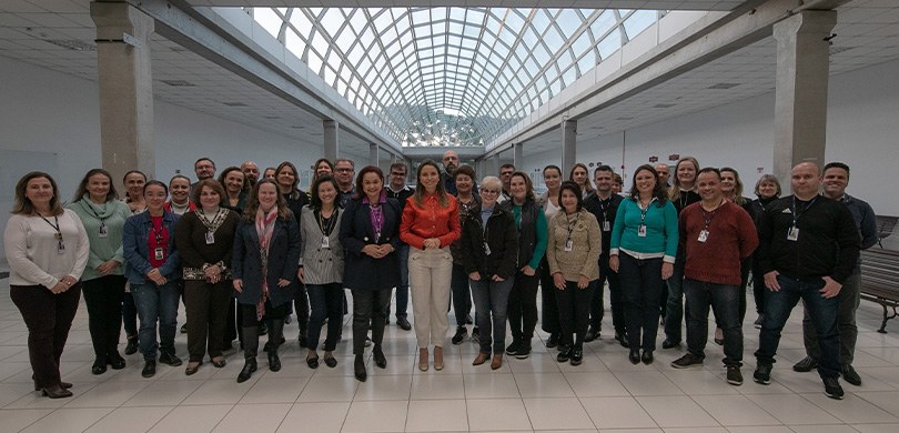 Fotografia de um grupo de diversas pessoas, entre homens e mulheres, posando sorrindo para foto....