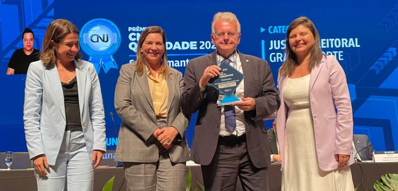 TRE-PR recebe Selo Diamante do Prêmio CNJ de Qualidade 1 Fotografia do presidente Sigurd Roberto Bengtsson segurando um troféu ao lado de outras três mul...