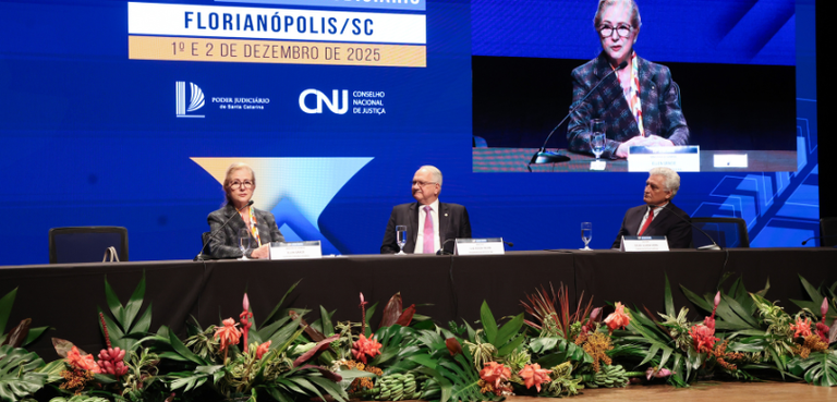 TRE-PR recebe Selo Diamante do Prêmio CNJ de Qualidade 3 Fotografia de uma mesa de autoridades, composta por dois homens e uma mulher, que aparecem senta...