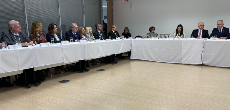 TRE-PR recebe Selo Diamante do Prêmio CNJ de Qualidade 4 Fotografia de diversas pessoas, entre homens e mulheres, sentadas diante de mesas brancas. Todos...