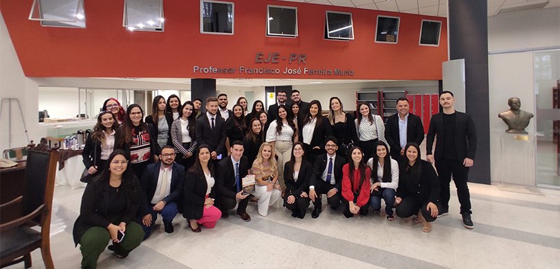 Um grupo de jovens estudantes, participantes da visita técnica posam para a foto no espaço da Es...